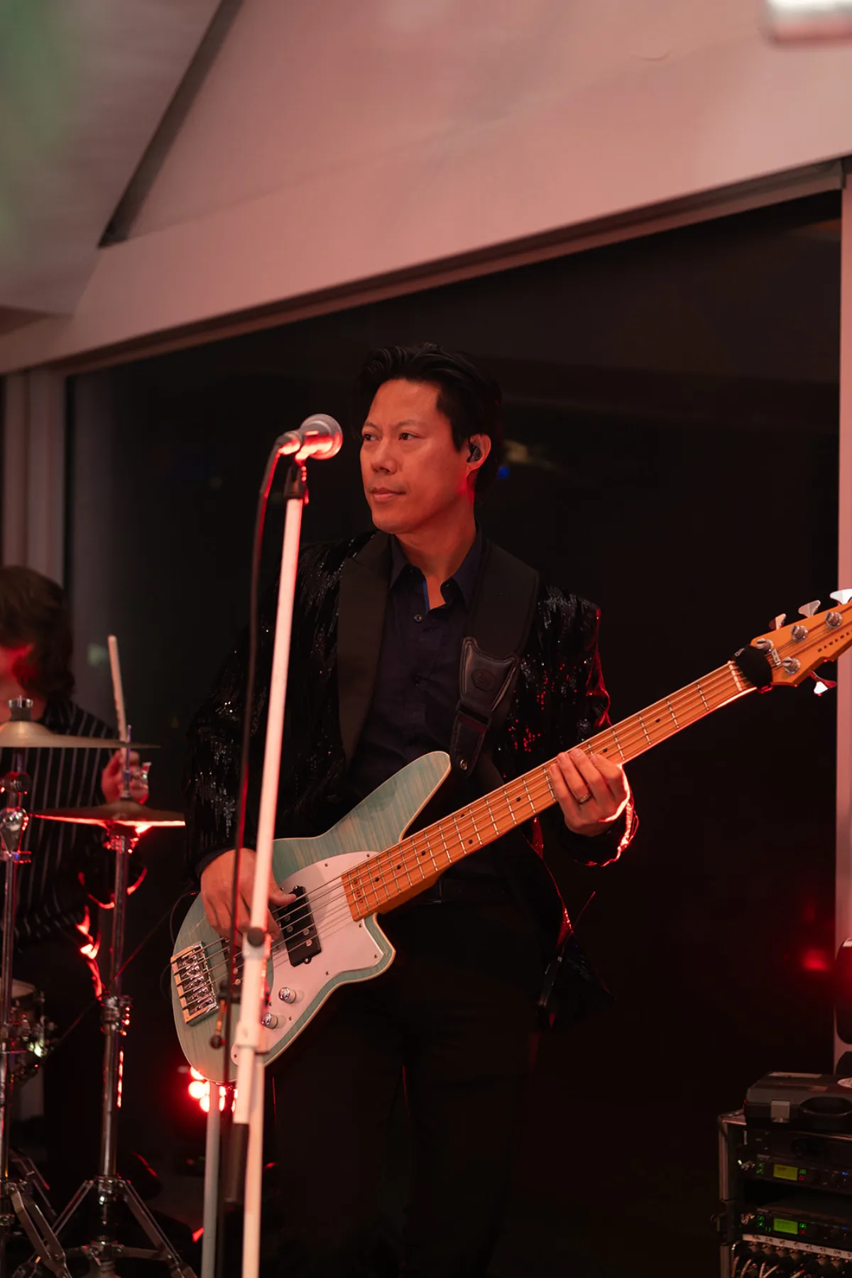 A live band on stage, bass player up front, during a company holiday party at the Roostertail in Detroit.