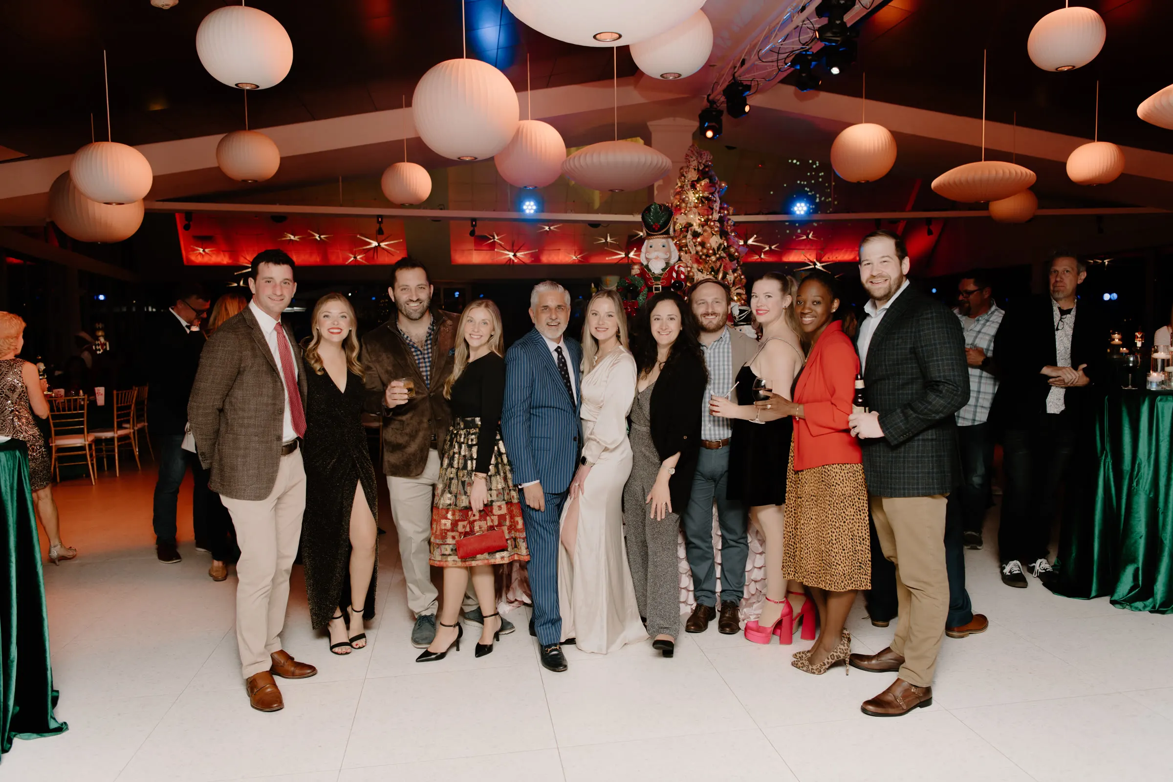 A company's guests gathered under paper lanterns at their holiday party