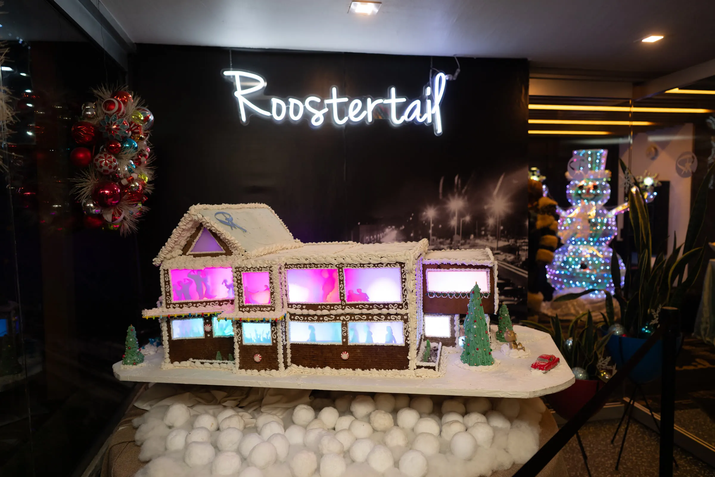 A gingerbread replica of the Roostertail under the neon script sign