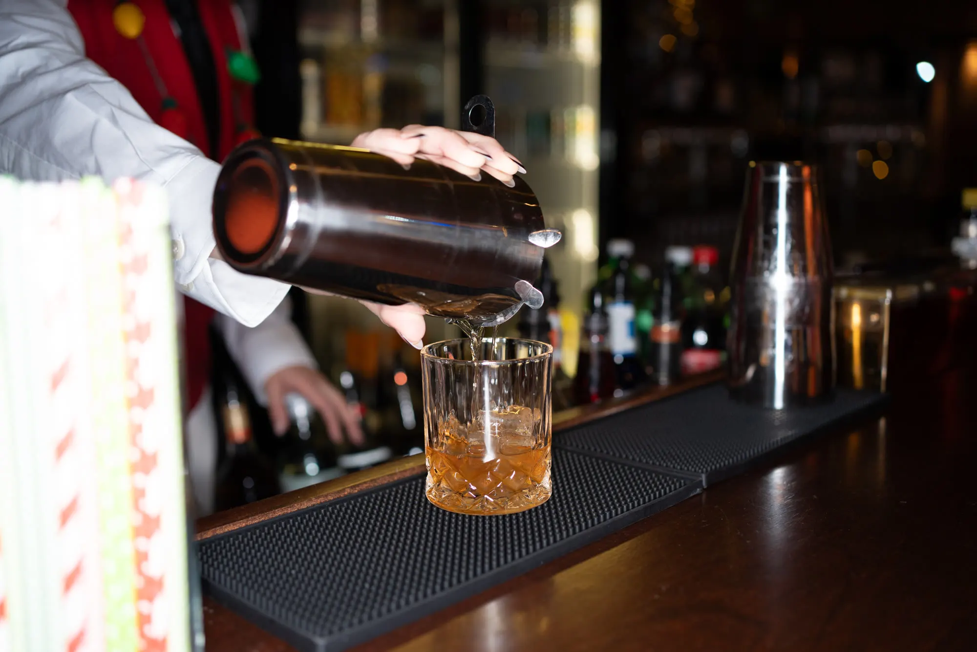 A Roostertail bartender pouring an old fashioned over a large ice cube