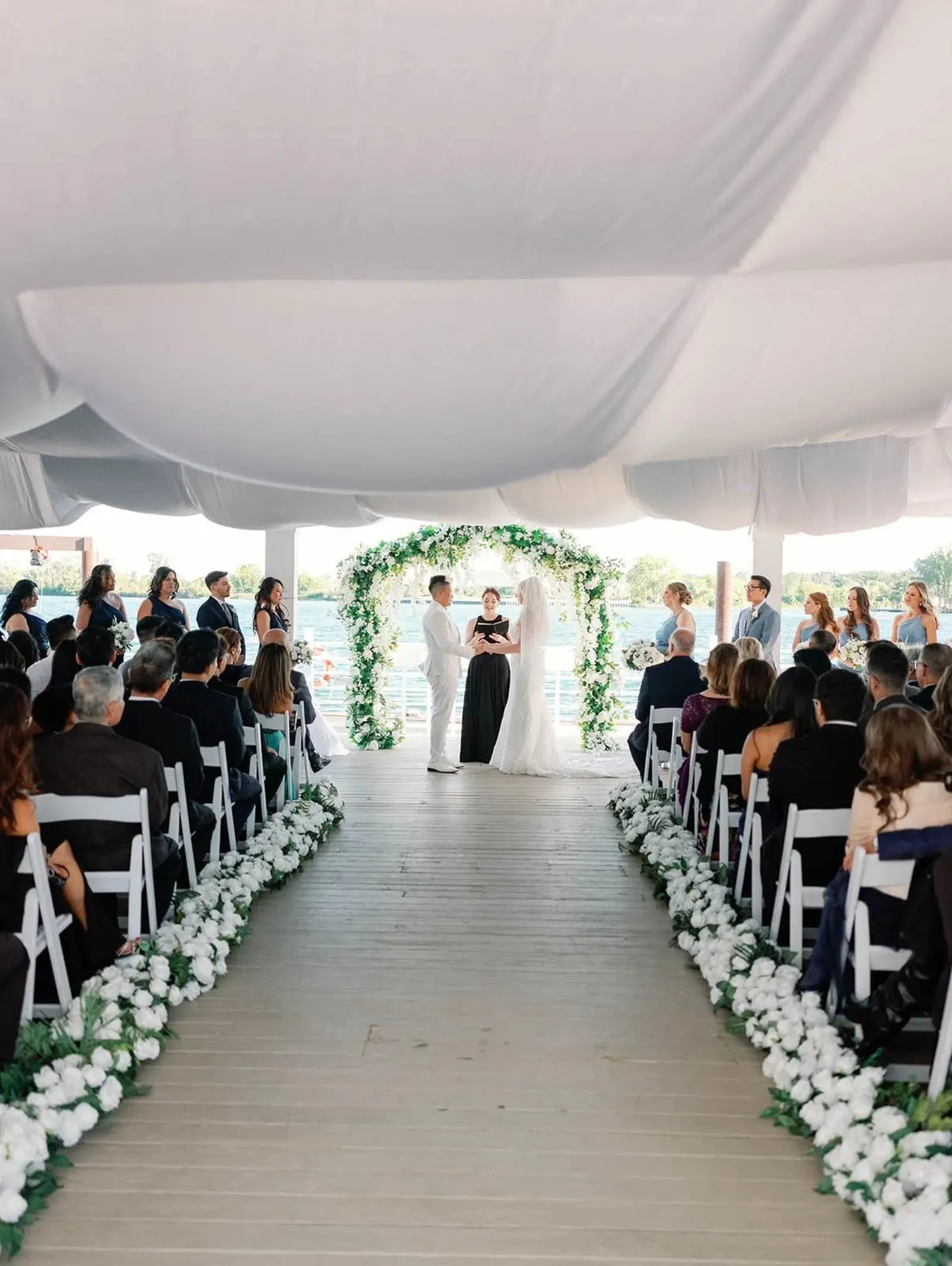 Wedding ceremony aisle on the dock at The Roostertail, Detroit River behind